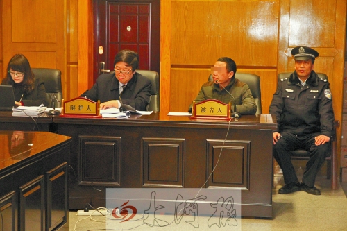 庭審現(xiàn)場，被告人坐在律師身旁為自己辯護。