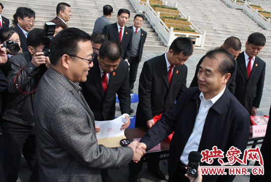 在新密市法院，省高院院長張立勇為拍得轎車的陳先生發(fā)放車鑰匙。