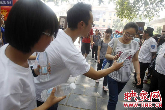 志愿者為剛剛考試完的考生送上1瓶冰凍的冰露·純悅，消暑解渴為考生加油