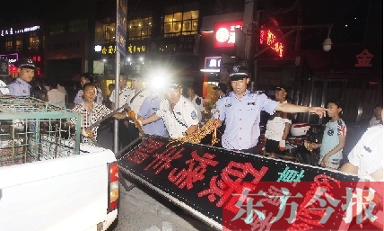 7月8日晚，鄭州市商城路一家占道經(jīng)營的攤販招牌被執(zhí)法隊員“登記保存”