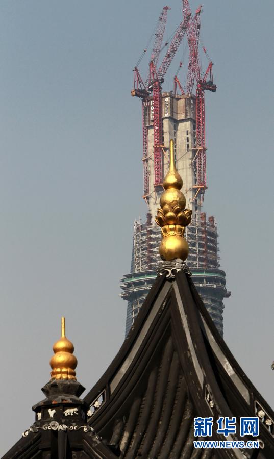 正在建設(shè)中的“上海中心”與豫園地區(qū)的傳統(tǒng)建筑（前）（4月11日攝）。