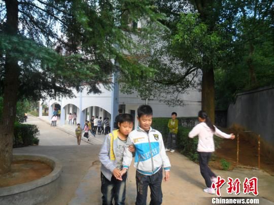 4年來，13歲的余興泉（左一）每天都攙扶著腿腳不便的同學(xué)左臣進(jìn)出教室、食堂和廁所。 李俊杰 攝