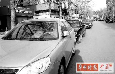 友愛(ài)路，路邊停了一排車，本來(lái)不寬的路就變得更窄了。
