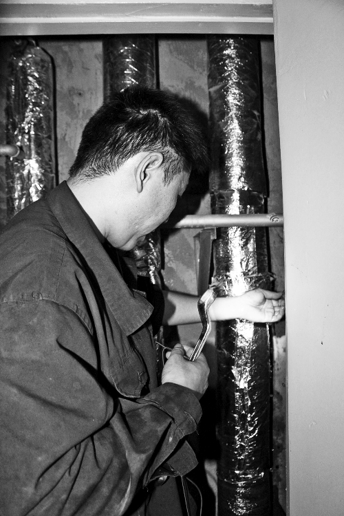 苗師傅一邊進(jìn)行維修，一邊用耳機(jī)接聽市民的電話。