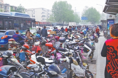 省人民醫(yī)院北門(mén)，路邊的公交站牌處停滿非機(jī)動(dòng)車(chē)，上、下客只能在快車(chē)道上。