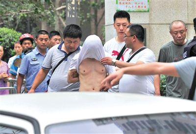 昨日，成都警方抓捕時(shí)與毒犯發(fā)生槍戰(zhàn)。一名男犯罪嫌疑人被警方押出。
