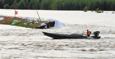 昨日，一艘搜救艇穿越堤壩決口進(jìn)入村中巡查。當(dāng)日，黑龍江堤防八岔段決口200米。新華社發(fā)