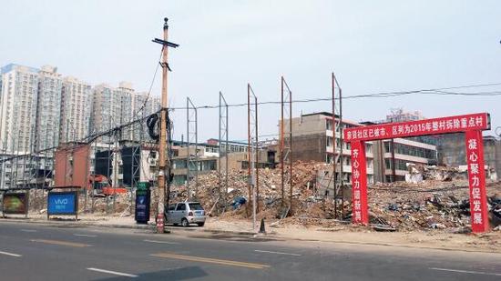 015年5月31日，在社區(qū)干部的帶頭拆遷下，親賢社區(qū)的“城中村改造”拉開帷幕。由于前期“清產(chǎn)核資”及補(bǔ)償標(biāo)準(zhǔn)等因素，拆遷改造工作推進(jìn)并不順利。圖為位于體育西路東側(cè)集體所有的商鋪率先被拆遷完畢，用于遮擋的圍擋正在施工中。（拍攝：2015年9月16日）