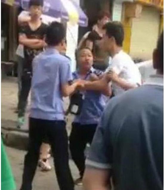 付某（右）與城管執(zhí)法人員廝打在一起。