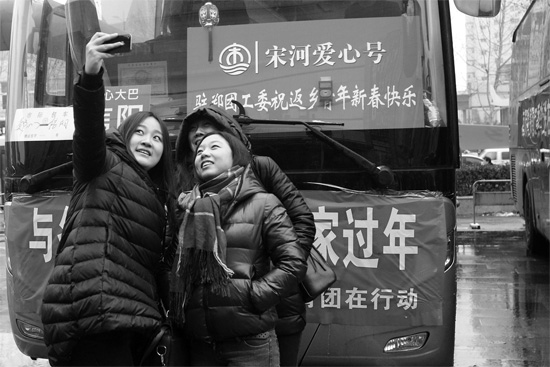 昨天上午8時(shí)，鄭州正道中環(huán)百貨廣場(chǎng)，準(zhǔn)備回家的老鄉(xiāng)在愛(ài)心大巴車前合影留念