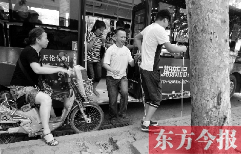 每到下車時(shí)，宋鵬（右一）和胡興開（右二）都很艱難，好在周圍的市民都挺照顧的