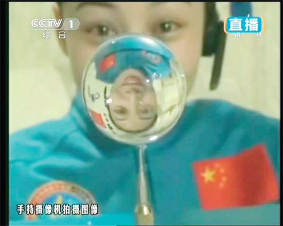 王亞平的倒影出現(xiàn)在水球中。新華社發(fā)（視頻截圖）