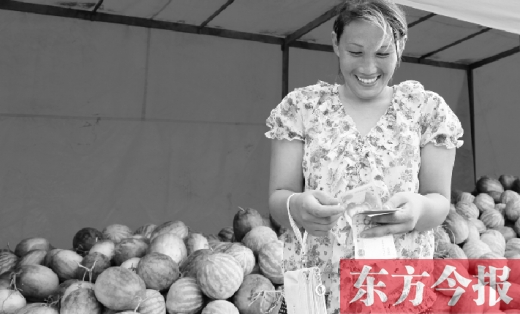 昨日，開封瓜農(nóng)史瑩瑩幸福地數(shù)著賣瓜錢 東方今報記者 沈翔 攝
