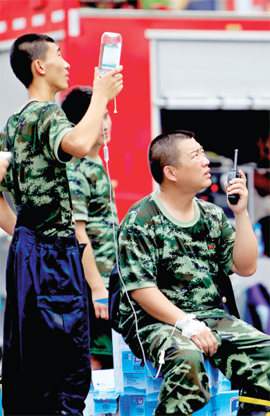 火場外，被消防戰(zhàn)士稱為“李大隊”的救援人員掛著吊瓶現(xiàn)場指揮