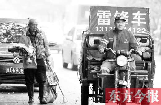 鄭州市商城路，一名環(huán)衛(wèi)工懷抱著剛剛收到的毯子，目送“雷鋒哥”孫德坤離開