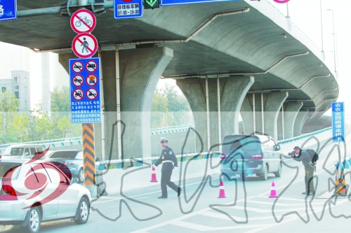 交警在東風(fēng)路從北向南上橋口處擺上反光錐，間歇放行
