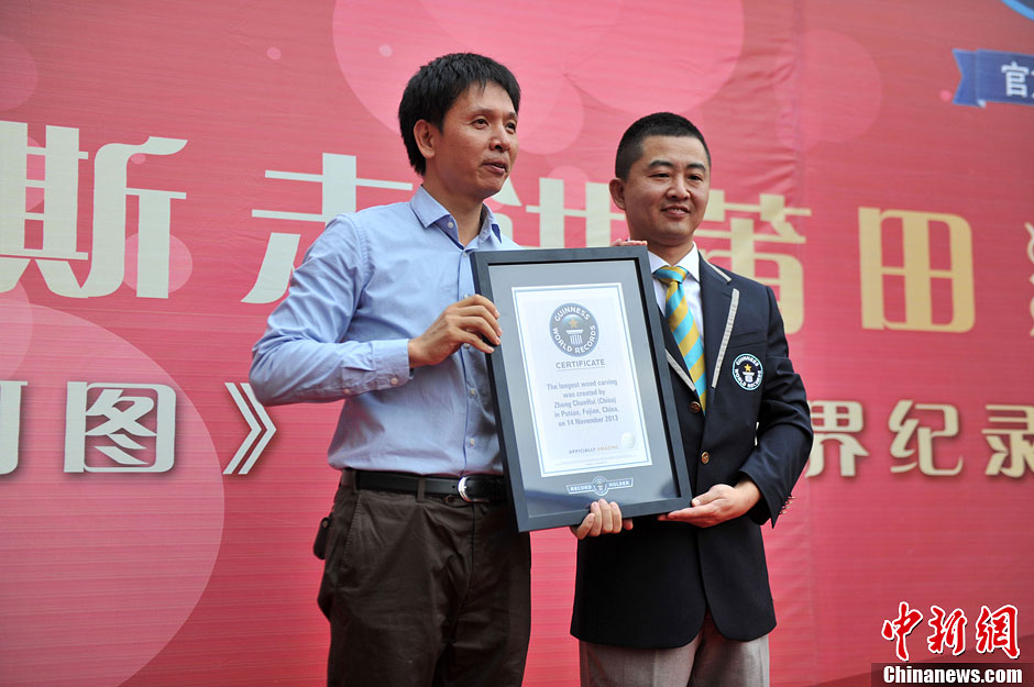 圖為世界吉尼斯認(rèn)證官為鄭春輝（左）頒發(fā)證書。呂明 攝