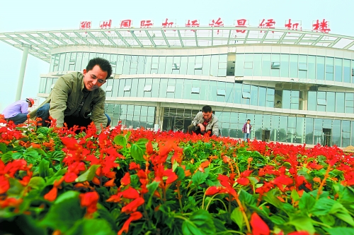 9月23日，工人們正在鄭州國際機(jī)場許昌候機(jī)樓前擺放鮮花。
