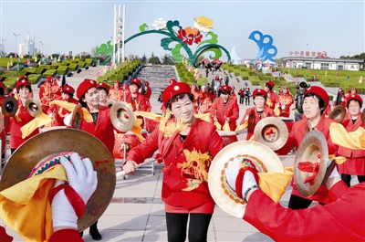 在中國(guó)國(guó)花園，伊川縣威武龍鼓藝術(shù)團(tuán)的精彩表演吸引眾多游客