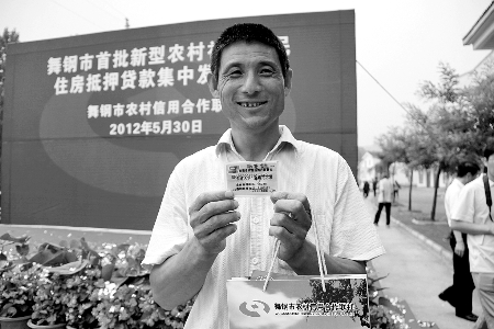領(lǐng)到貸款，農(nóng)民開心地笑了。