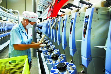 7月3日，在鄧州市永泰棉紡有限公司電腦控制全自動紡紗車間，紡織工人正在生產(chǎn)棉紗。
