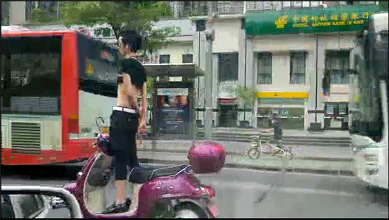 奇葩男子電動(dòng)車上秀雜技 戴墨鏡大撒把