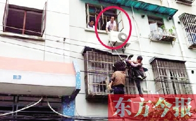 施救現(xiàn)場(chǎng)，劉鵬（圈內(nèi)）先用繩子捆住老太確保安全 勞動(dòng)報(bào)記者 郭娜 供圖