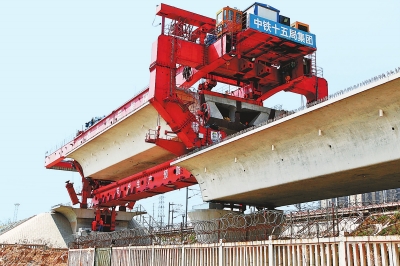 建設(shè)者們操縱巨型起重機(jī)在吊放橋墩。記者鄧放攝