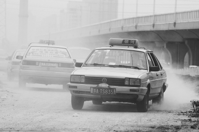 施工的道路上，車輛通過塵土飛揚。