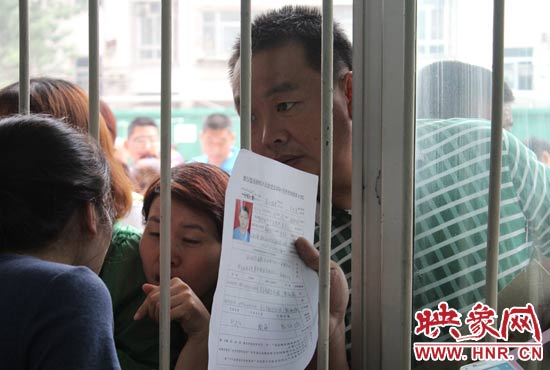 不少家長(zhǎng)擠在報(bào)名窗口前咨詢報(bào)名事宜。
