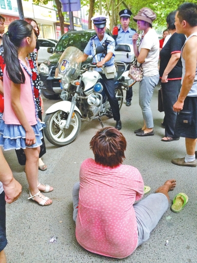 在鄭州優(yōu)勝南路東三街交叉口向東100米處，一名短發(fā)中年女子平躺在路南快車道上，身旁還有一只掉落的拖鞋