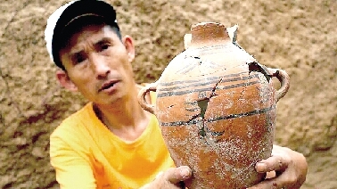 　　考古工作人員展示出土的仰韶文化時期代表性彩陶。
