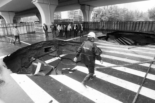 中原路西三環(huán)立交橋下由南向北原本4個車道，由于塌坑，而今3個車道被圍擋
