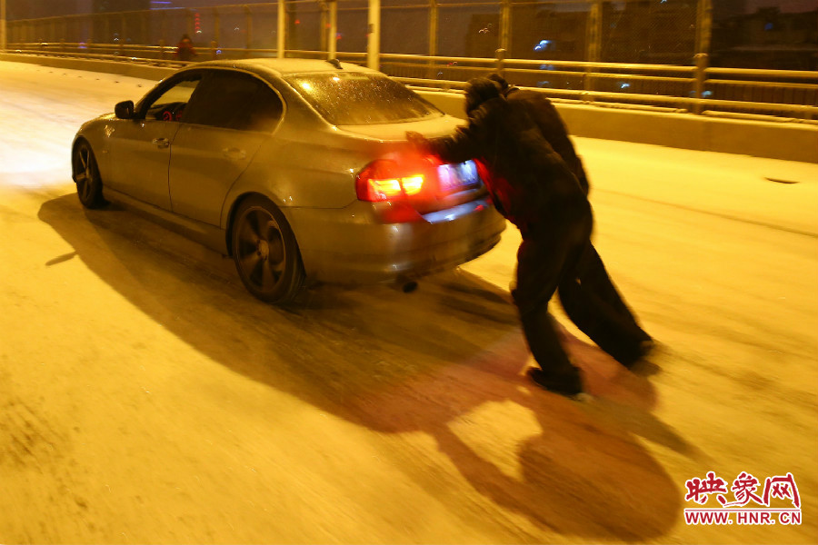 兩位“推車人”奮力的推著小車上橋。