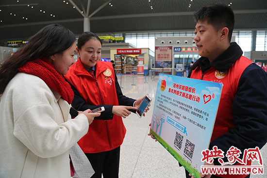 志愿者為旅客講解“網(wǎng)絡文明志愿”的行動內(nèi)容。