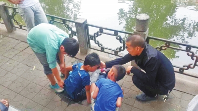 男孩被救出后，圍觀群眾幫他控水換衣服。