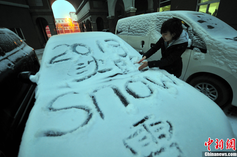 11月18日，行人在車輛的積雪上涂鴉。