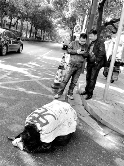 兩名接訪人員與患有癌癥的訪民段新德合影時(shí)，在拍照時(shí)查看手機(jī)。