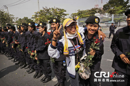 2013年12月03日,曼谷總理府與曼谷警署允許反政府示威民眾進(jìn)入,雙方進(jìn)入暫時(shí)“停戰(zhàn)”狀態(tài)迎接泰王生日。曼谷警察總署,女警們手持鮮花送給反政府示威民眾。圖片來源:Manish Swarup/東方IC