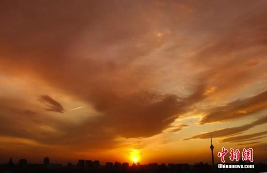 12月8日下午，強烈的西北風(fēng)光臨北京，吹散了籠罩全城上空的霧霾，冬日罕見的艷麗晚霞映紅了半邊天。