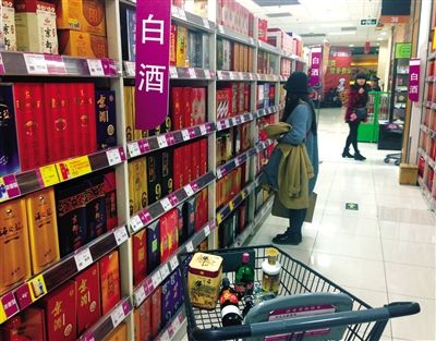 顧客在商場的高檔白酒貨架前駐足挑選。春節(jié)臨近，受“禁令”影響，以高檔白酒為代表的節(jié)日禮品市場面臨考驗。記者 王遠征 攝