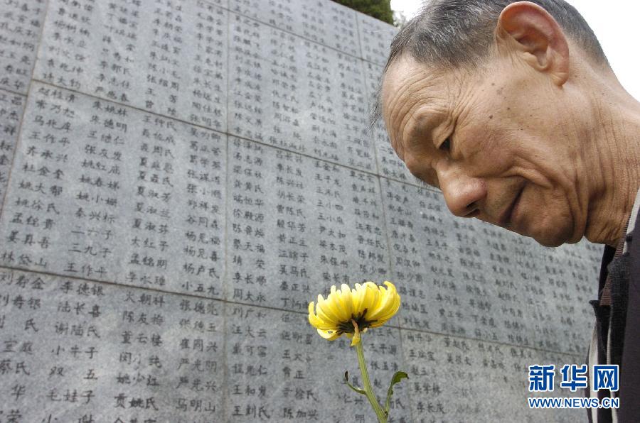 2006年4月5日，74歲的南京大屠殺幸存者佘子清手捧鮮花，祭奠被日軍殺害的母親。