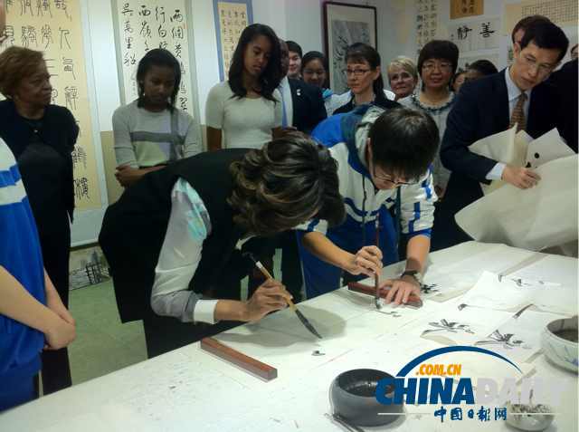 　北京時(shí)間3月21日，美國第一夫人米歇爾參觀北師大二附中時(shí)，與學(xué)生一起練習(xí)書法。