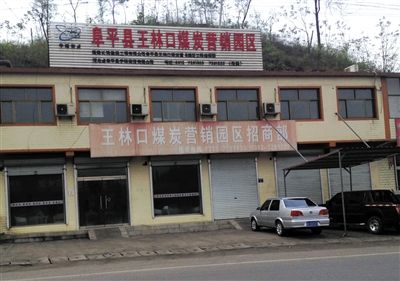 4月23日，王林口煤炭營(yíng)銷園區(qū)招商部窗上還貼著“河北省阜平縣重點(diǎn)工程”的宣傳貼。新京報(bào)記者 張永生 攝