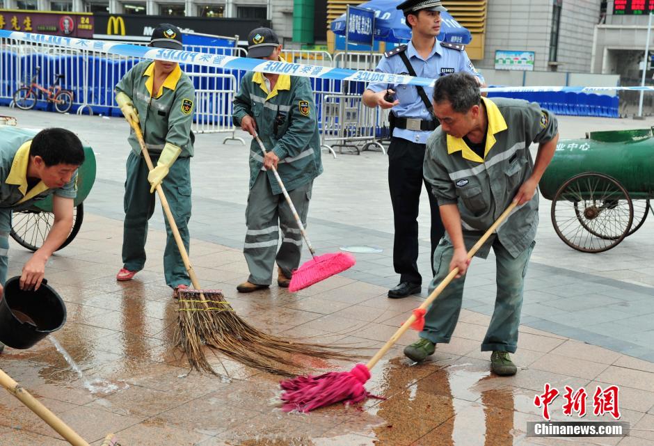 圖為環(huán)衛(wèi)工人在清理案發(fā)地點(diǎn)的血跡。