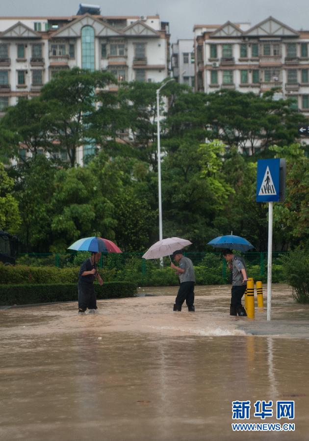 5月11日，人們在深圳西麗涉水行走。