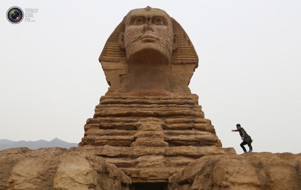 石家莊郊外，一名男子與山寨版獅身人面像合影留念。