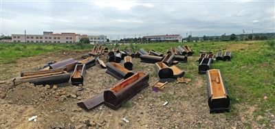 40多副棺木被砸壞后，扔在荒地上。