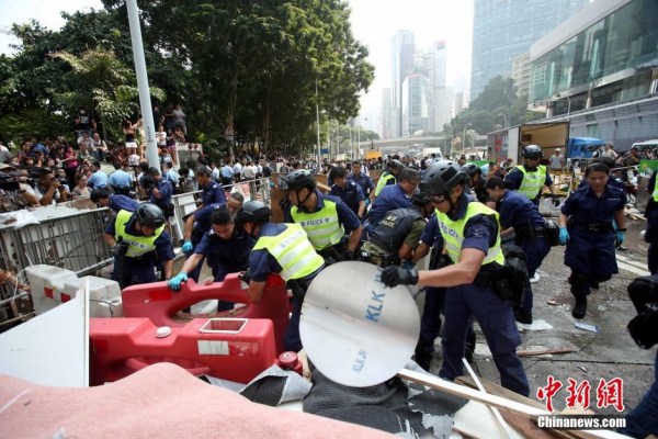 10月14日，警方清除金鐘道障礙物。大批警員在金鐘道現(xiàn)場清拆障礙物。部分警員戴上頭盔將障礙物移走。