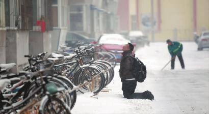 小伙子跪在樓前，一直抬頭看著樓上。 孫立國(guó)/攝